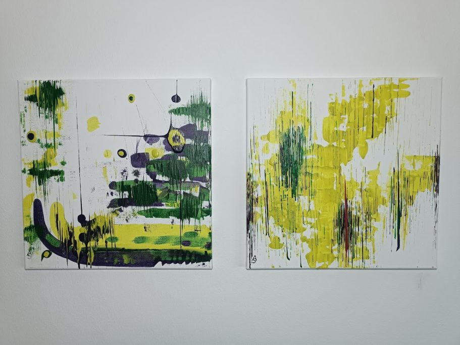 Zwei farbenfrohe abstrakte Gemälde in Gelb, Grün und Violett an einer weißen Wand.