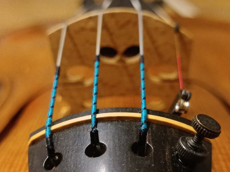 Nahaufnahme einer Violine mit sichtbaren Saiten und Hals.